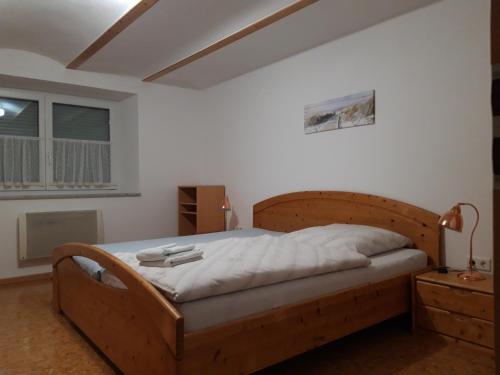 sypialnia z drewnianym łóżkiem i oknem w obiekcie Ferienwohnung im Seidlerhof mit Terrasse w mieście Röhrnbach