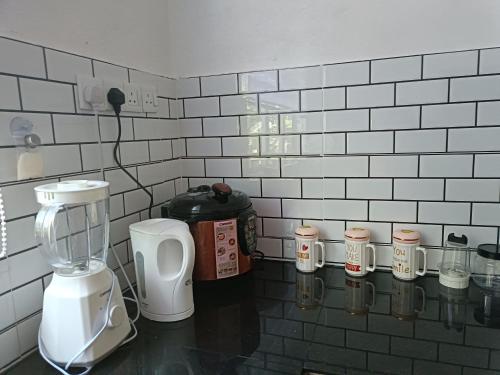 a kitchen with a counter with a blender and cups at Aila Homestay Pendang in Pendang