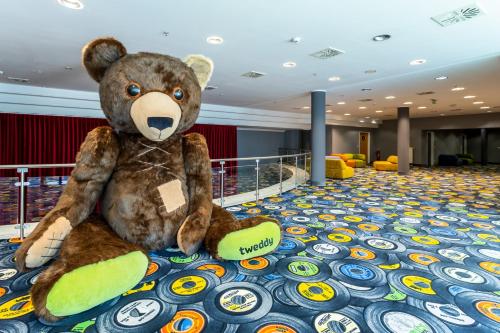 a teddy bear sitting on the floor of a room at mightyTwice Hotel Dresden in Dresden