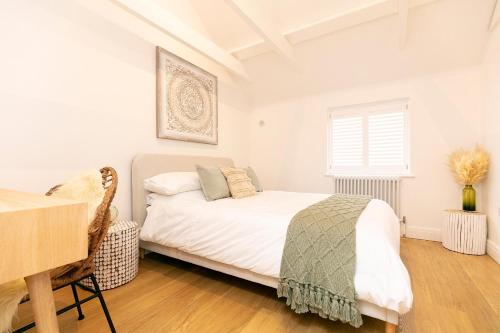 a white bedroom with a bed and a desk at Whitstable Wishes, a Stylish Seaside Retreat, Whitstable with Parking Space in Whitstable