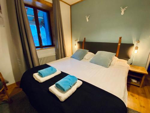 een slaapkamer met een groot bed en handdoeken bij Chalet Le Rêve in Vénosc
