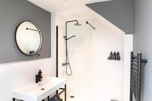 a bathroom with a shower and a sink and a mirror at Whitstable Wishes, a Stylish Seaside Retreat, Whitstable with Parking Space in Whitstable