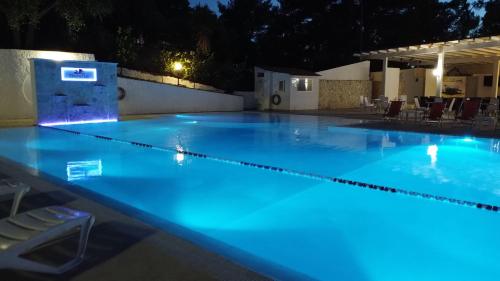 an empty swimming pool at night with blue lights at Villaggio Elisena in Vieste