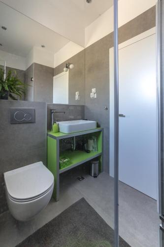a bathroom with a white toilet and a sink at Villa Bamboo in Duće
