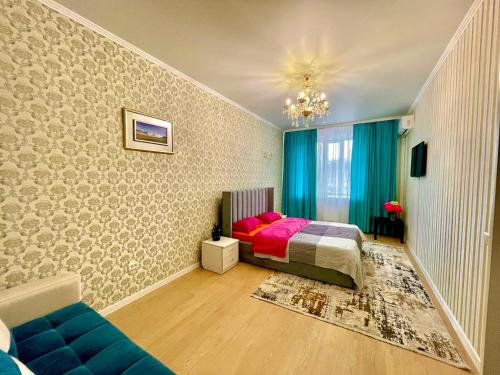 1 dormitorio con 1 cama y 1 sofá azul en 1 комнатные апартаменты en Pavlodar