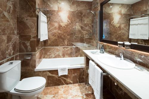 een badkamer met een toilet, een wastafel en een bad bij Catalonia Portal de l'Angel in Barcelona