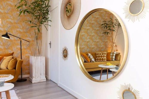ein Wohnzimmer mit einem Sofa und einem Spiegel in der Unterkunft Appartement biarritz beaurivage. Chez Rodolphe in Biarritz
