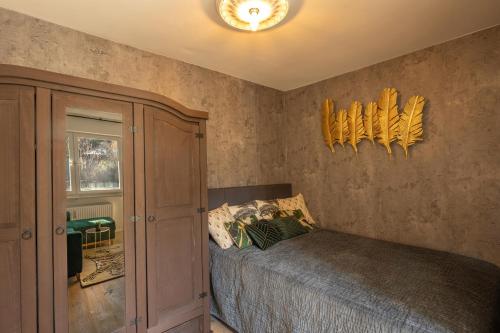 a bedroom with a bed with yellow feathers on the wall at SweetHome - Luxus pur - Küche, Balkon, WiFi in Dachau