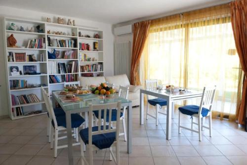 een eetkamer met een tafel en stoelen en boekenplanken bij Casa Vacanza Le Fresie in Nuoro