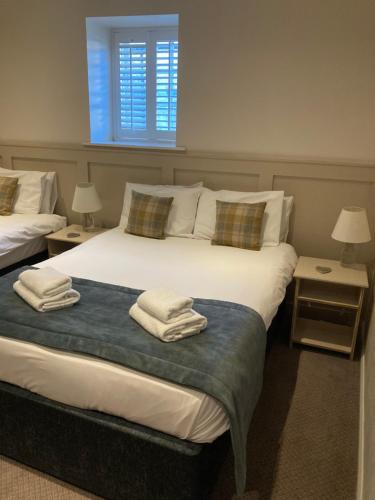 a bedroom with two beds with towels on them at The Midland Hotel in Leeds