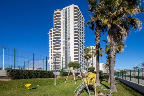 a tall white building with a playground in a park at ESPACIO 5 - Primera Línea de Playa in Cullera