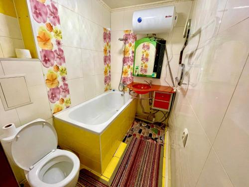 uma casa de banho com um WC, uma banheira e um lavatório. em Квартира в центре Павлодара em Pavlodar