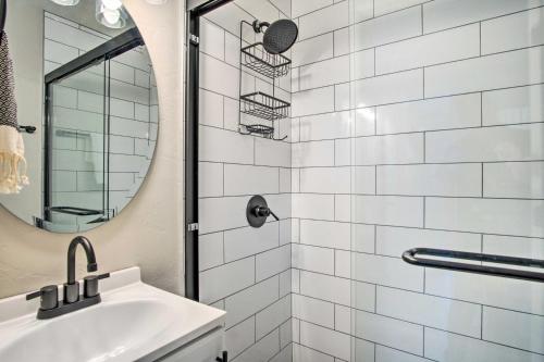 a white bathroom with a sink and a mirror at Lovely Tucson Home about Walk to Reid Park Zoo! in Tucson