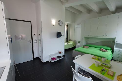 ポッツァッロにあるVacanze a Casa Pozzalloの緑のベッド、テーブル、椅子が備わる客室です。