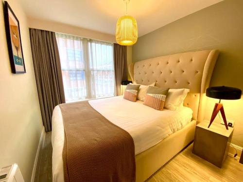 a bedroom with a large bed with a large window at Beautiful 2 Bedroom Apartment - 1 Minute walk to Poole Quay - Great Location - Free Parking - Fast WiFi - Smart TV - Newly decorated - sleeps up to 4! Close to Poole & Bournemouth & Sandbanks in Poole