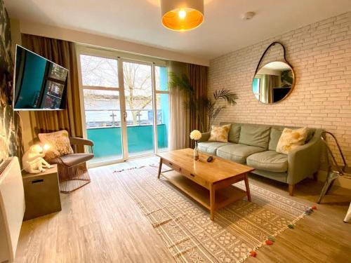 a living room with a couch and a table at Beautiful 2 Bedroom Apartment - 1 Minute walk to Poole Quay - Great Location - Free Parking - Fast WiFi - Smart TV - Newly decorated - sleeps up to 4! Close to Poole & Bournemouth & Sandbanks in Poole