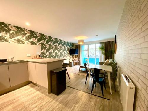 a kitchen and living room with a table and chairs at Beautiful 2 Bedroom Apartment - 1 Minute walk to Poole Quay - Great Location - Free Parking - Fast WiFi - Smart TV - Newly decorated - sleeps up to 4! Close to Poole & Bournemouth & Sandbanks in Poole