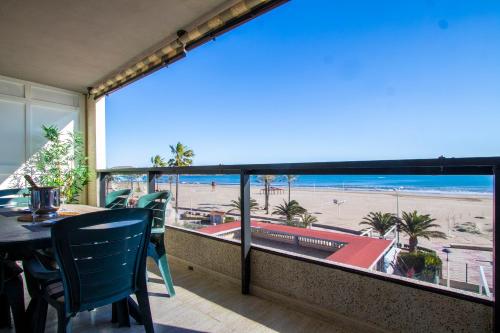 balcón con mesa y sillas y vistas a la playa en ESPACIO 2 Primera LINEA DE PLAYA, en Cullera