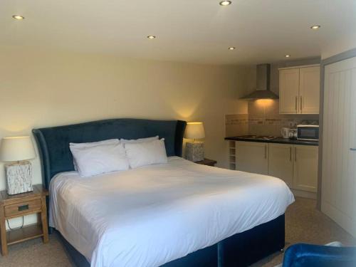 a bedroom with a large bed and a kitchen at Palmer's Ale House in Long Sutton