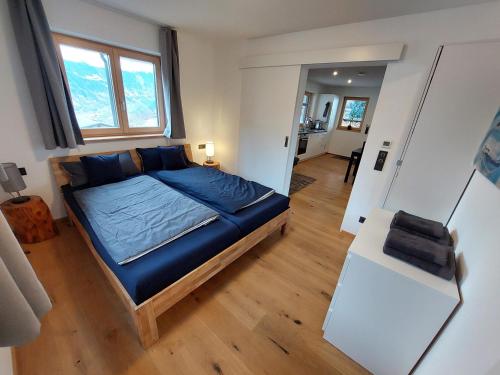 um quarto com uma cama azul num quarto em Haus Ströhle em Schruns