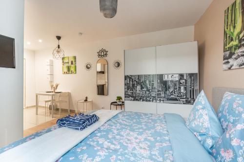 - une chambre avec un lit bleu et une table dans l'établissement Sweethost - La Zen Room - Studio Proche Gare & Disneyland, à Lagny-sur-Marne