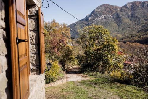 a view of a dirt road with mountains in the background at Πέτρινη κατοικία με υπέροχη θέα στο όρος Κόζιακα. in Longiaí