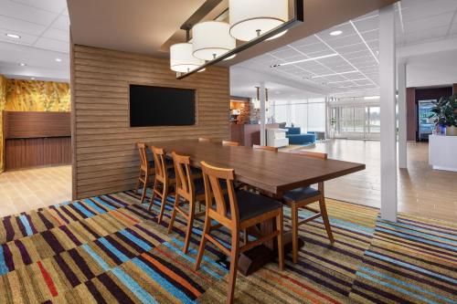 a dining room with a wooden table and chairs at Fairfield Inn & Suites by Marriott Poplar Bluff in Poplar Bluff