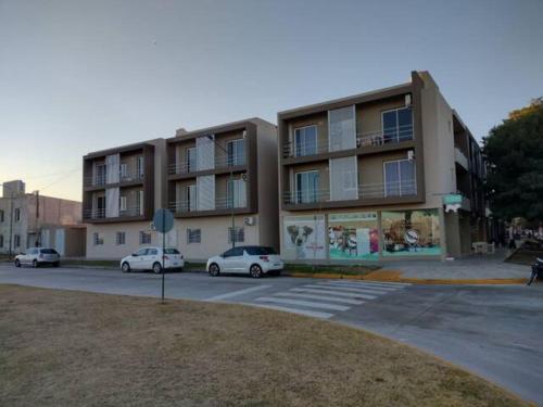 dos coches estacionados frente a un edificio en Residencia Merlo en Rafaela