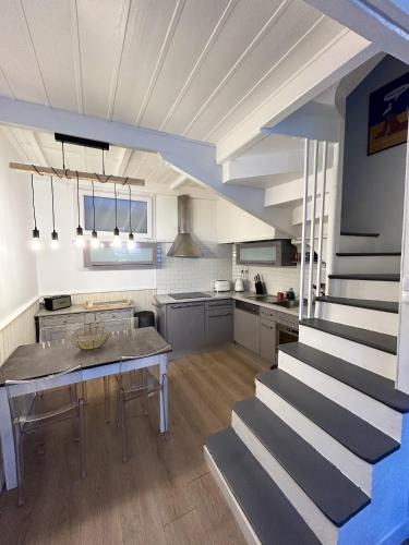 une grande cuisine avec une table et un escalier dans l'établissement Maison chaleureuse à Trouville-sur-Mer avec vue sur la ville, à Trouville-sur-Mer