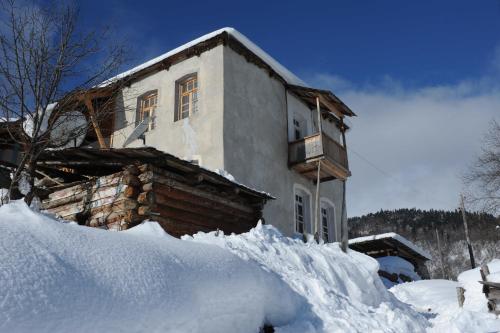 a house with a pile of snow in front of it at Guest House Murkvam in Tvebishi