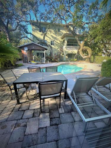 a patio with a table and chairs next to a pool at Siesta Key Bay View Beach Access in Siesta Key