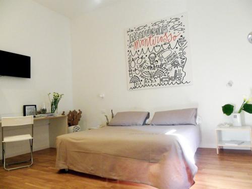 a bedroom with a bed and a desk with a television at Affittacamere Altamarea in La Spezia