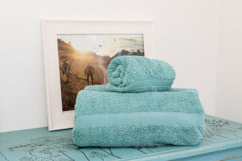 a stack of towels sitting on a table next to a picture at Queens Park View - 1 Bedroom in Bournemouth