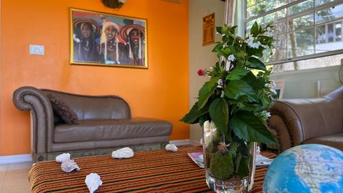 a living room with a vase of flowers on a table at All Nations Guest House in Port Antonio