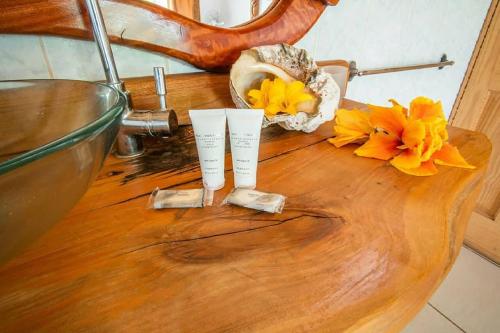 a wooden table with two cups on top of it with flowers at CHEZ MARIA GORETTI HOTEL in Hanga Roa