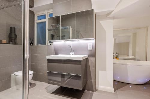 a bathroom with a sink and a toilet and a tub at Period 3-Bed Maisonette next to the City of London in London