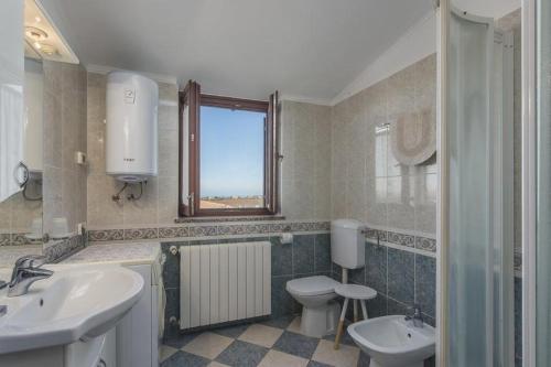 a bathroom with two sinks and a toilet and a window at Appartment Arrburoni in Novigrad Istria