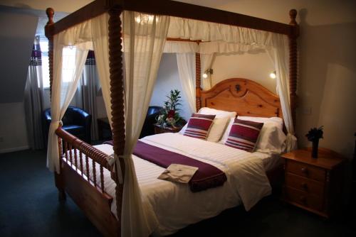 
a large bed with a canopy on top of it at The White Hart Inn in Llandeilo
