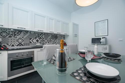 cocina con mesa de cristal y armarios blancos en Real Italian Estate - Luxury Black&White, en Génova
