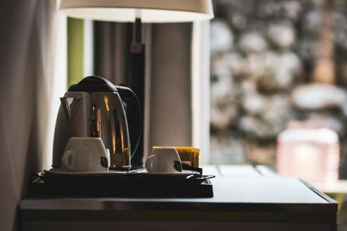 una cafetera y dos tazas en una mesa en San Valentino Hotel en Villa di Serio