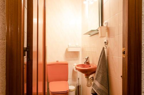 a bathroom with a pink toilet and a sink at Barcelona Beach Home in Barcelona