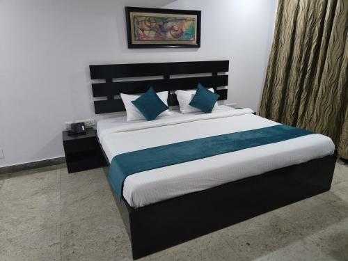 a bedroom with a large bed with blue pillows at CABANA REGENCY in Gurgaon