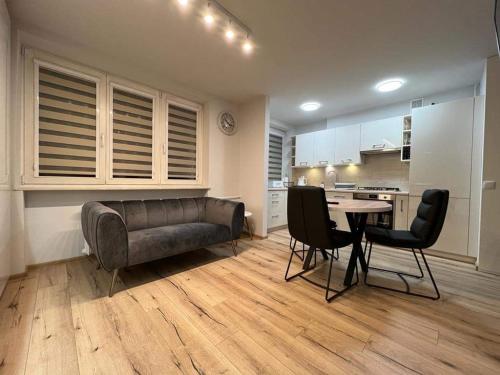 a living room with a couch and a table and chairs at MW3 Apartament in Rzeszów