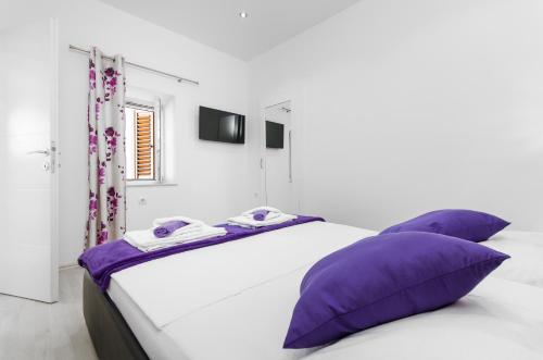 sypialnia z dużym łóżkiem z fioletowymi poduszkami w obiekcie Apartment Borovac w mieście Vrgorac