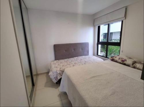 1 dormitorio con cama y ventana en Holandas Prime em Tambaú a 100mts da Praia, en João Pessoa