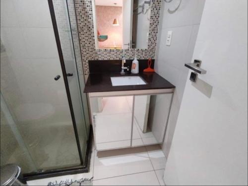 y baño pequeño con lavabo y ducha. en Holandas Prime em Tambaú a 100mts da Praia, en João Pessoa