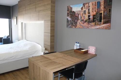 1 dormitorio con 1 cama y mesa de madera con sillas en 5 yıldızlı Dedeman’da özel residence dairesi en Kocaeli