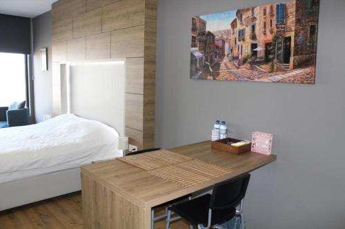 1 dormitorio con 1 cama y mesa de madera con sillas en 5 yıldızlı Dedeman’da özel residence dairesi, en Kocaeli