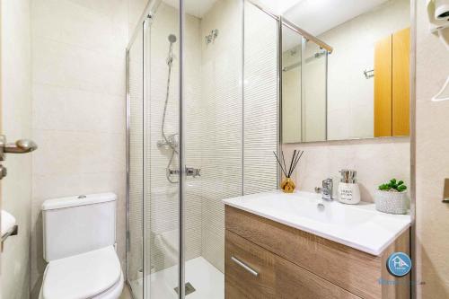 y baño con ducha, aseo y lavamanos. en Premium Bajo Carlos Haya con Terraza y Parking, en Málaga