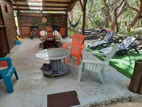 eine Gruppe von Stühlen und einem Tisch auf einer Terrasse in der Unterkunft Chalet de Bérènice in Saint-Joseph